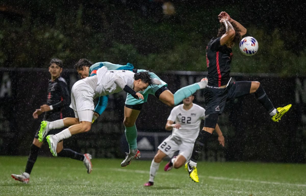 Seattle Pacific University midfielder Raymundo Mendez (3) is taken out by the Northwest Nazarene goalkeeper during the second half of an NCAA D2 soccer match on Thursday, Nov. 9, 2023, in Seattle.