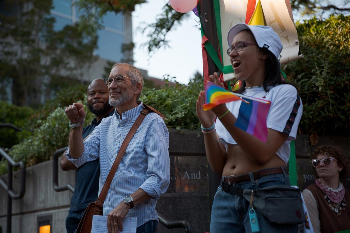 Dr. Kevin Neuhouser (left) points in support of a student speaker during a demonstration in Martin Square on Monday, Sept. 12, 2022, in Seattle. The demonstration was an announcement and commemoration of the lawsuit that students, faculty, and staff members brought against the Seattle Pacific University Board of Trustees. 