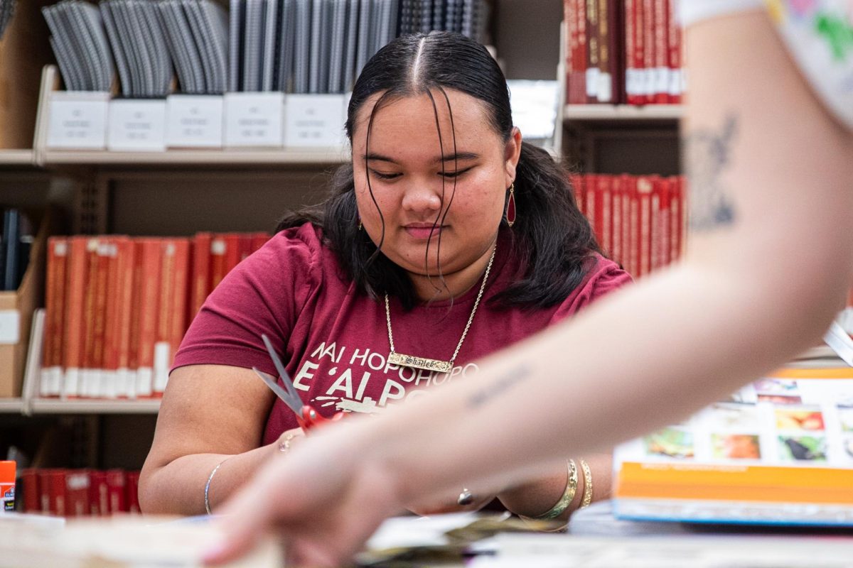 Freshman Shailey Makahanaloa Valoroso cuts participates in a collaging activity during at Library Fest in Ames Library on Thursday, Sept. 21, 2023.