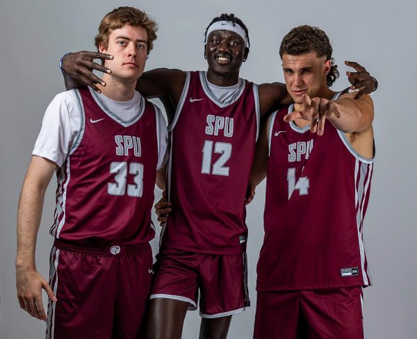 From left to right Seattle Pacific University forward Nikias Schoenerstedt (33), Seattle Pacific University center James Agany (12) and Seattle Pacific University forward Trace Evans (14) pose for a photo on media day, Sept. 28, 2023, in Seattle.