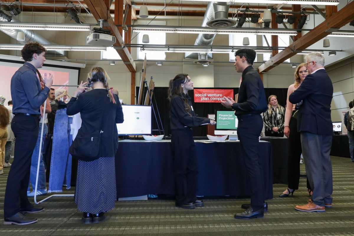 Judges, students, and competitiors wander through the Social Venture Plan Competition on Thursday, April 18, 2024, in Seattle.