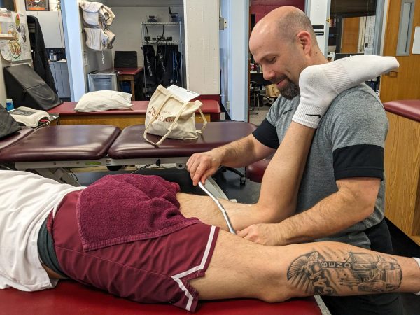 Seattle Pacific University lead athletic trainer Jason Durocher works on an athlete in the training room on Wednesday, April 17, 2024, in Seattle.