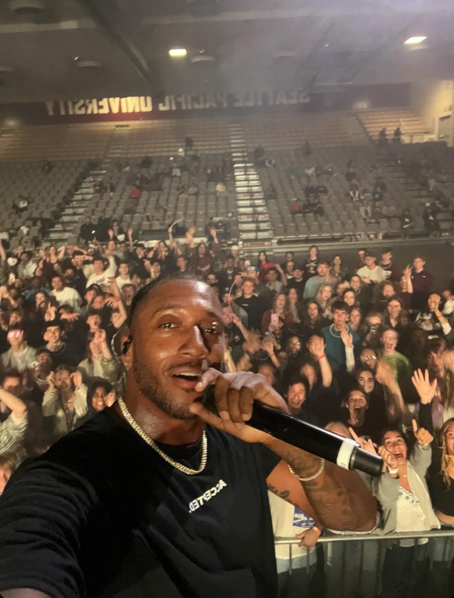 Lecrae poses for a photo with SPU after commandeering freshman Arishia Eilbeigi's phone.