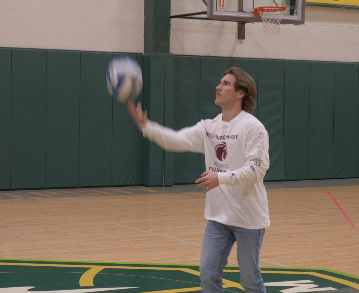 Senior Justice Dean tosses a volleyball in Royal Brougham Pavilion's lower basketball court. 