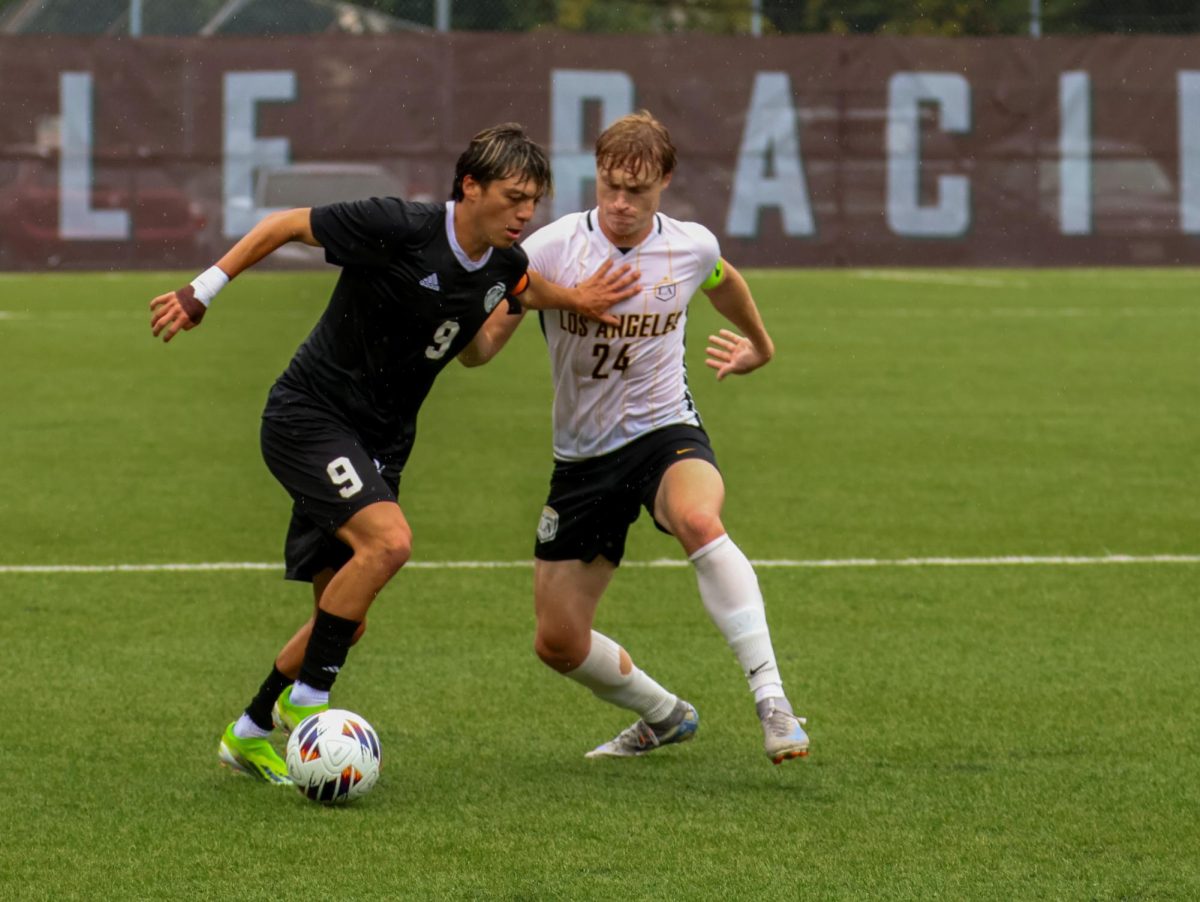 Senior Raymundo Mendez (9) fights to keep the ball against Chico State.