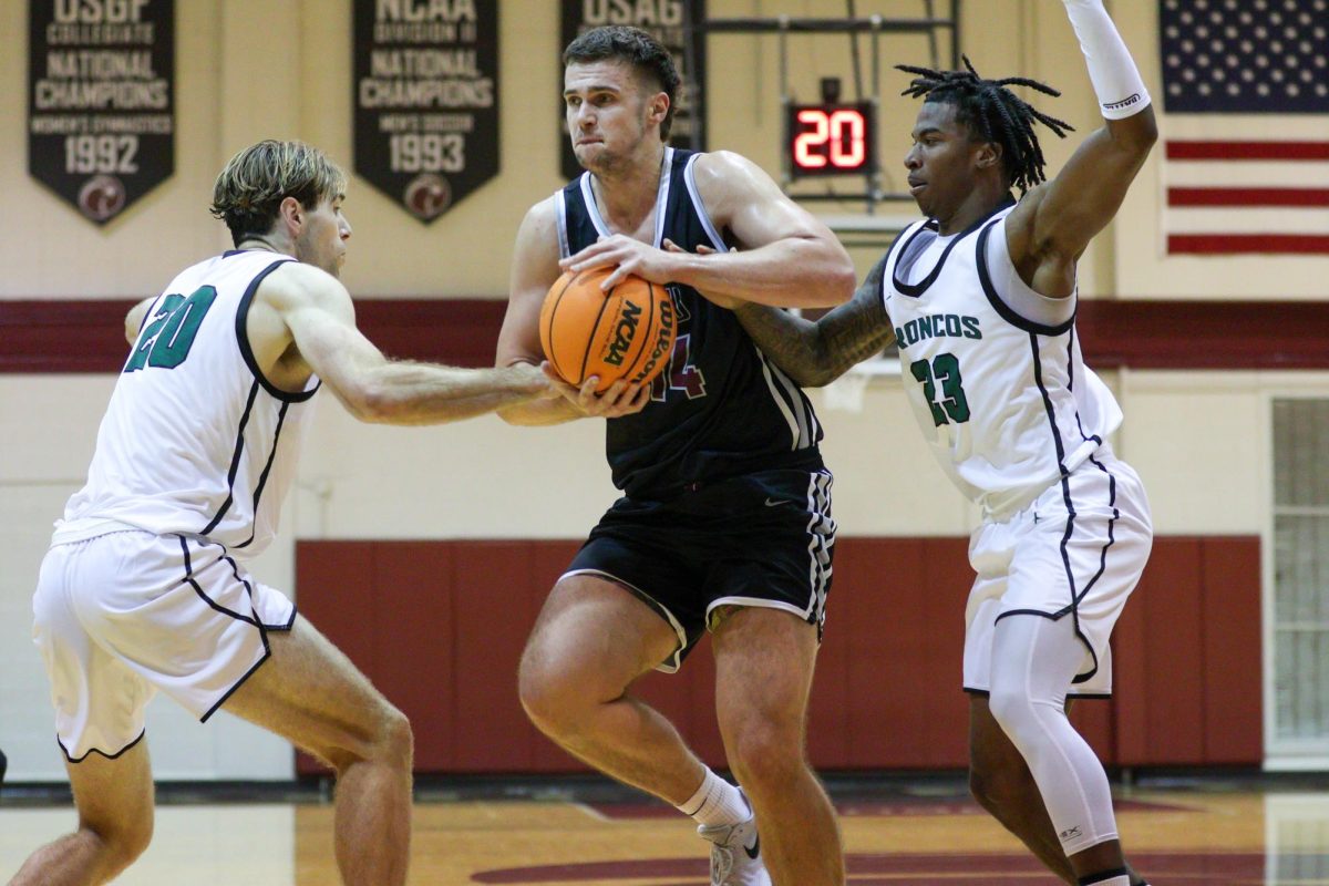 SPU Junior Trace Evans (14) trucks through against Cal Poly Broncos to make a layup on Saturday, Nov. 11, 2024, In Seattle.