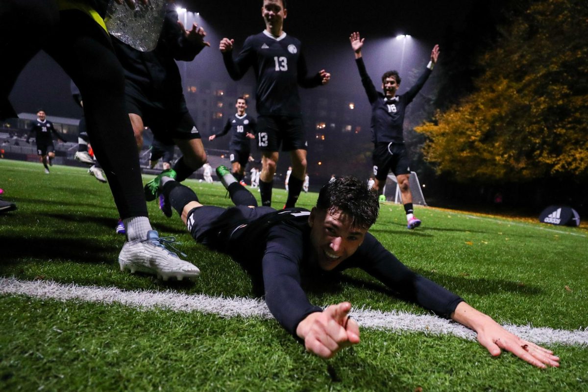 Seattle Pacific University freshman defender Carter Gay (12) slides across the sideline in celebration after scoring to put his team up 3-1 in the second half against Montana State University Billings on senior night, Saturday, Nov. 16, 2024, in Seattle.