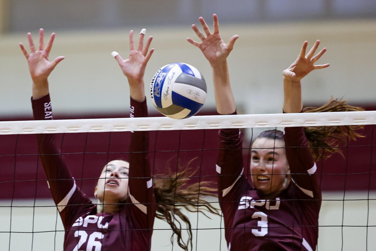 Fifth year Sydney Perry (26) and freshman Eva LaRochelle (3) block the volleyball against Western Washington University on Nov. 9, 2024 in Seattle.