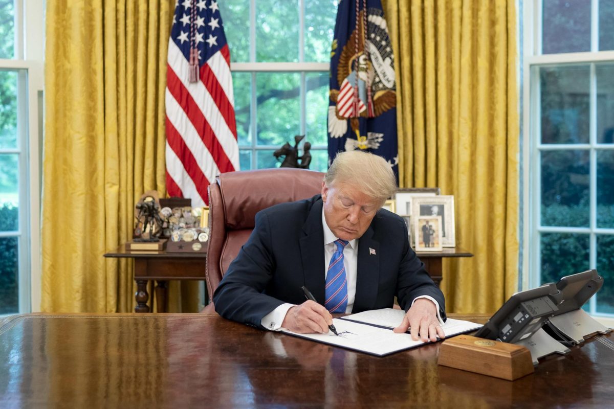 President Donald J. Trump signs an Executive Order on Protecting American Monuments, Memorials, and Statues and Combating Recent Criminal Violence, Friday, June 26, 2020, in the Oval Office of the White House. (Official White House Photo by Tia Dufour)