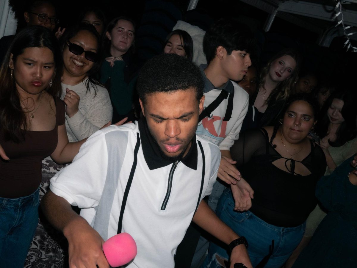 Ethan Jenkins sings amidst a crowd of students during Argosy Cruise in Seattle, Friday, Oct. 17, 2025.
