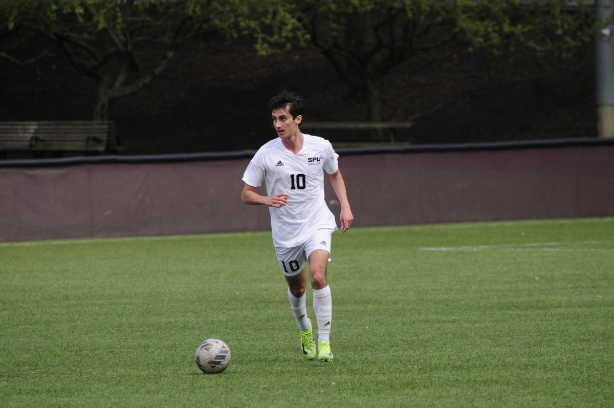 Senior Connor Tollan dribbling the ball against SPU Alumni March 29 2025. 