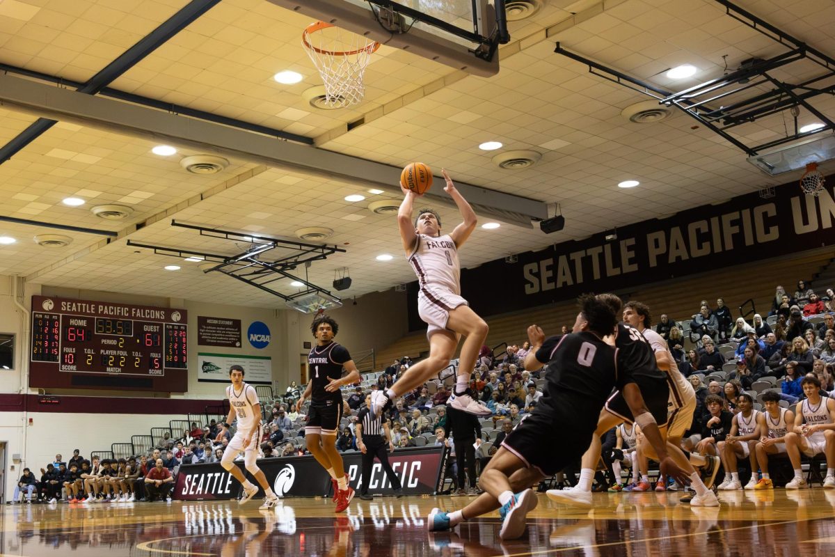 Junior Theo McMillan jumps to shoot a basket against Central Washington Universary