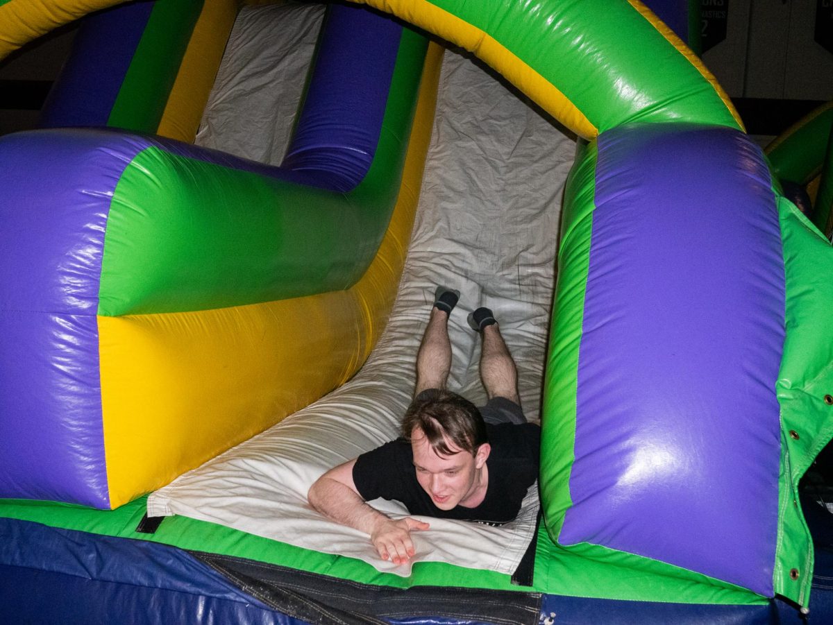 Senior Ryan Fecarotta slides down a bouncy house at First Friday in Seattle, Friday, March 27, 2026.